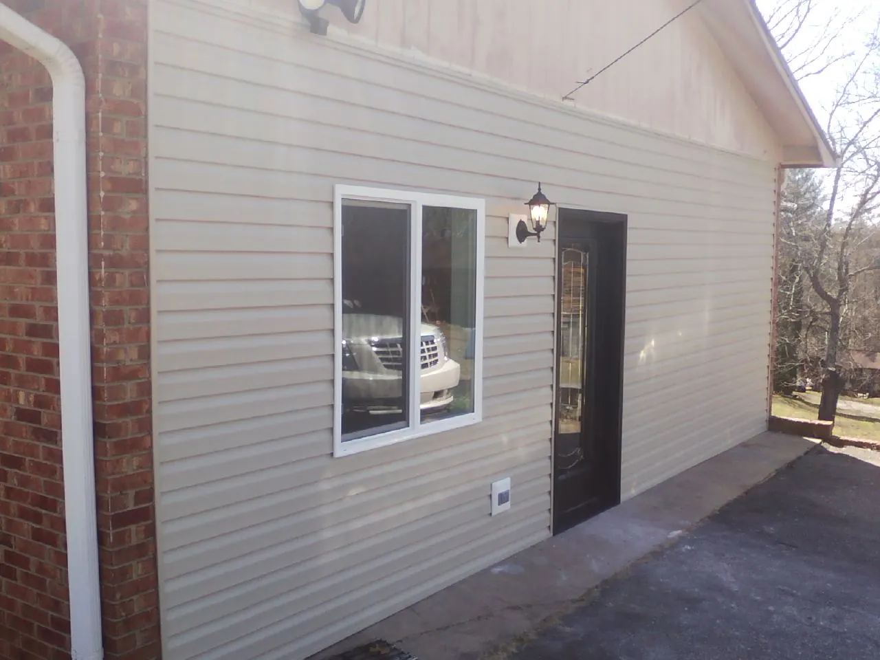 New vinyl siding and entry door on a room addition in Whitten
