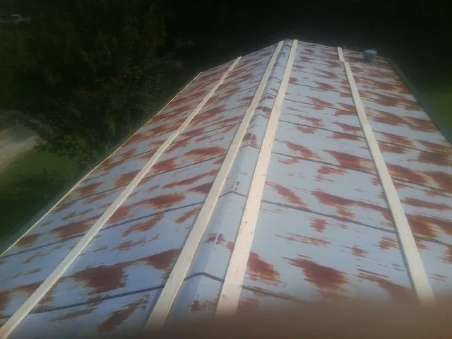 Rusted metal roof panels with new wood purlins before replacement — Storm Damage Roof Repair in Whitten by Roofing Brothers