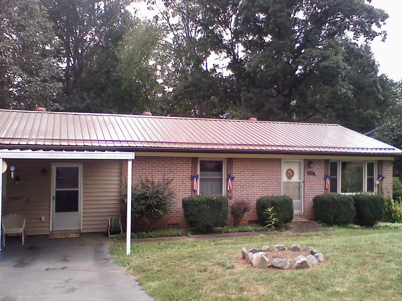 Bronze metal roof and carport on a brick ranch home — Roof Repair work by our crew in Whitten